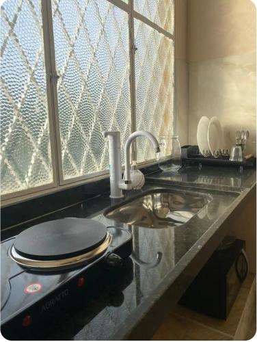 a kitchen counter top with a sink and a counter top at Loft Campinho 2 in Estação Inhoaíba