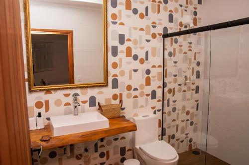 a bathroom with a toilet and a sink and a mirror at Fazenda Castanheira in Monte Verde