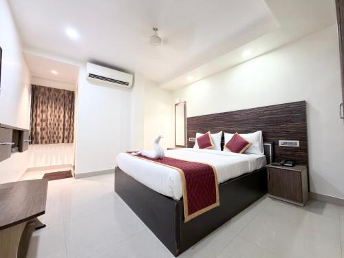 a bedroom with a large bed and a bathroom at Malaysia inn in Chennai