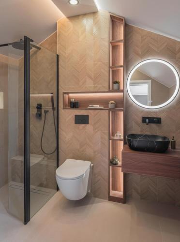 a bathroom with a toilet and a shower and a mirror at Villa JAM in Kaštela