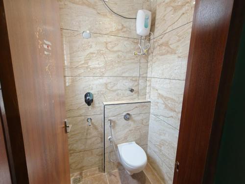 a bathroom with a toilet in a shower at Sathya Bay in Marakkānam