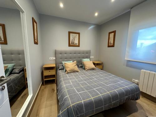 a bedroom with a bed with a blue blanket at Apartamento do Lagar, Praia da Abrela in O Vicedo