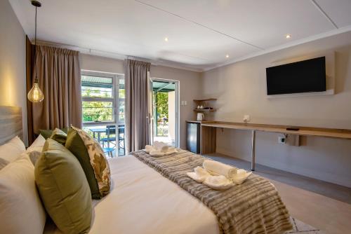 a living room with a large bed and a television at Arebbusch Travel Lodge in Windhoek