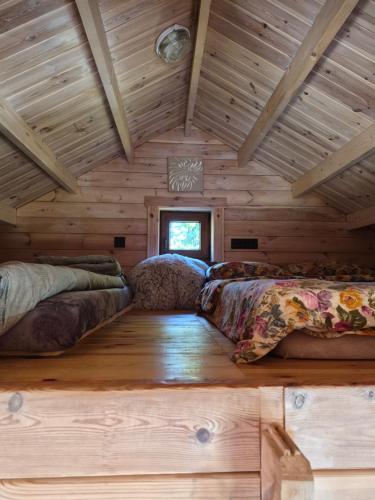 a bedroom with two beds in a log cabin at Sodyba 15 Ąžuolų Svečių namai 2 in Triušiai