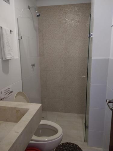 a bathroom with a shower and a toilet and a sink at Hotel Baos in Sincelejo