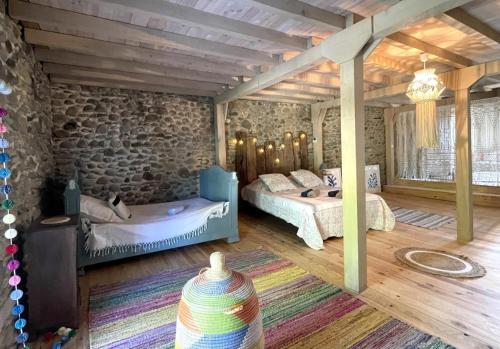 ein Schlafzimmer mit zwei Betten und einer Steinwand in der Unterkunft Elissabide in Espès - Undurein