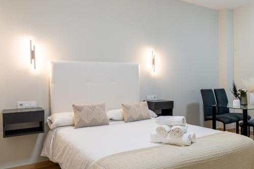 a bedroom with a bed with towels on it at Oasis La Corredera, En Pleno Casco Histórico in Córdoba