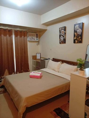 a bedroom with a bed with a pink box on it at New Centrio Tower Lovely Studio adj Ayala CDO in Cagayan de Oro