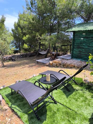 a table and chairs on the grass in a yard at Paradise kosirina in Murter