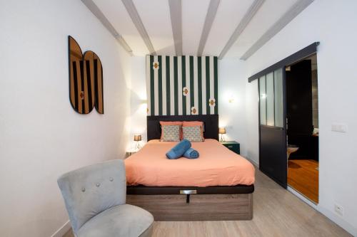 a bedroom with a bed and a chair at Suite Lyséa - Balnéothérapie au Coeur d'Annecy in Annecy