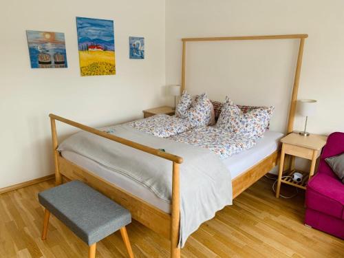 a bedroom with a bed with a wooden frame and a chair at Ahrweiler Seelchen in Bad Neuenahr-Ahrweiler