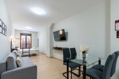 a living room with a couch and a glass table at Oasis La Corredera, En Pleno Casco Histórico in Córdoba