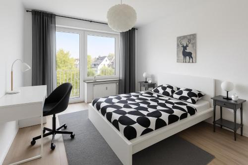 a bedroom with a bed and a desk and a window at Pulheim Living 6 in Pulheim