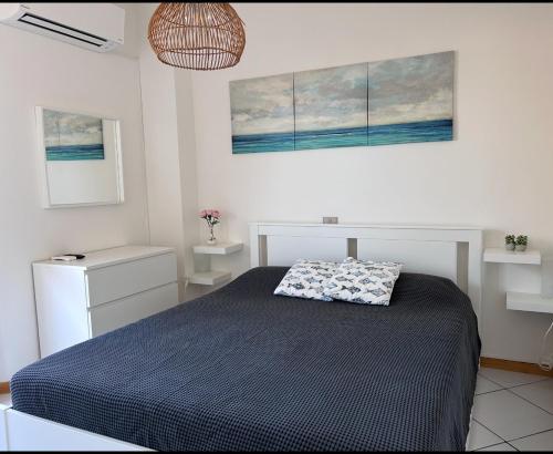 a bedroom with a bed and two pictures on the wall at daNilomare in Marcelli