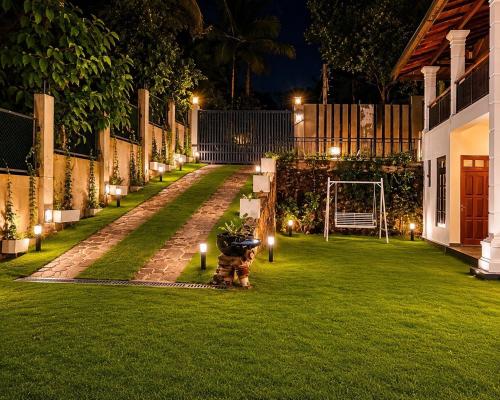 a garden at night with lights on the grass at Emerald Edge Villa in Minuwangoda