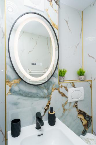 a bathroom with a mirror and a white sink at Joy Apartament in Nehoiu