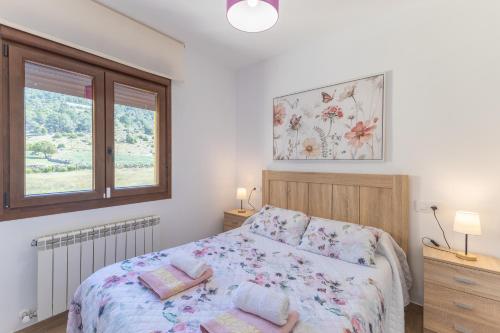 a bedroom with a bed and two windows at Chalet Pinara in El Barraco