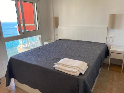 a bedroom with a bed with two towels on it at Veracruz-Fincas Benidorm in Benidorm