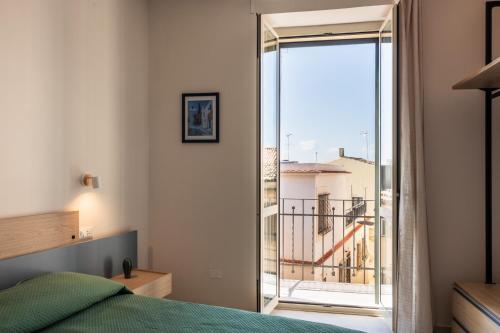 a bedroom with a bed and a view of a balcony at Casa Amarantia-Appartamento 1 in Noto