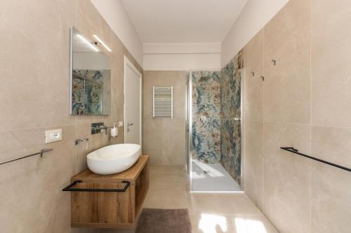 a bathroom with a white sink and a shower at Casa Amarantia-Appartamento 1 in Noto
