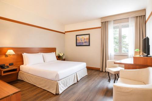 ein Hotelzimmer mit Bett und Schreibtisch in der Unterkunft SHG Hotel Bologna in Zola Predosa