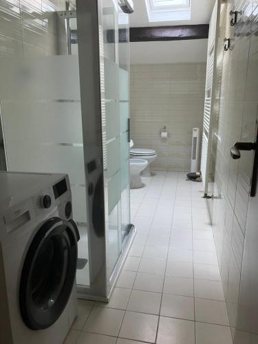a bathroom with a washing machine and a toilet at Fondobanchetto in Ferrara