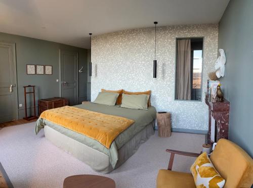 a bedroom with a large bed with an orange blanket at Hôtel Particulier Nontron - chambre d'hôtes et meublés de tourisme in Nontron