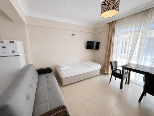 a living room with a couch and a table at Limon Pansiyon Burhaniye in Burhaniye