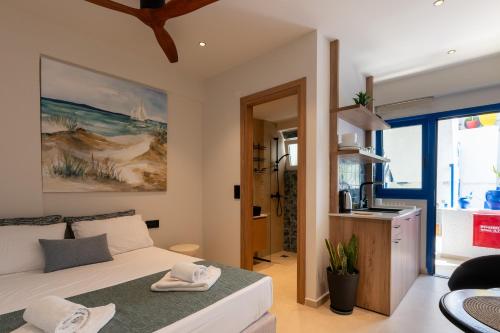 a bedroom with a bed and a kitchen in a room at Psaras Apartments in Stalís