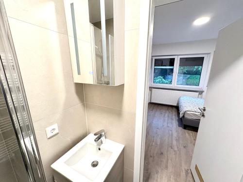 a small bathroom with a sink and a window at Cozy Room Echterdingen Stuttgart Airport & Messe in Leinfelden-Echterdingen