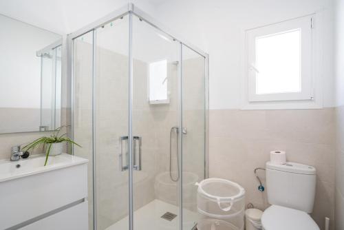 a bathroom with a glass shower stall and a toilet at La Tertulia in Zahora