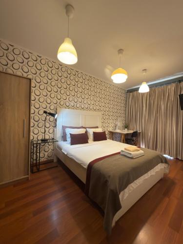 a bedroom with a large bed and two lights at Quarto Bica Central in Lisbon