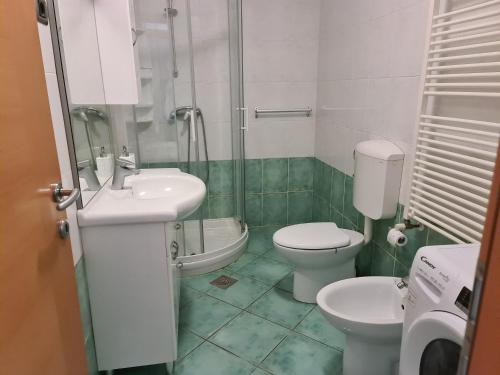 a bathroom with two toilets and a sink and a shower at Alloro in Ankaran