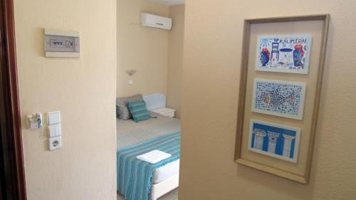 a room with a bedroom with a bed and a mirror at Namastekala Holidays Studios in Chrysi Ammoudia