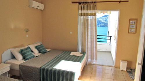 a bedroom with a bed with a view of the ocean at Namastekala Holidays Studios in Chrysi Ammoudia