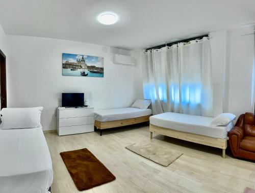 a room with two beds and a couch and a tv at Venice Night 11 in Mestre