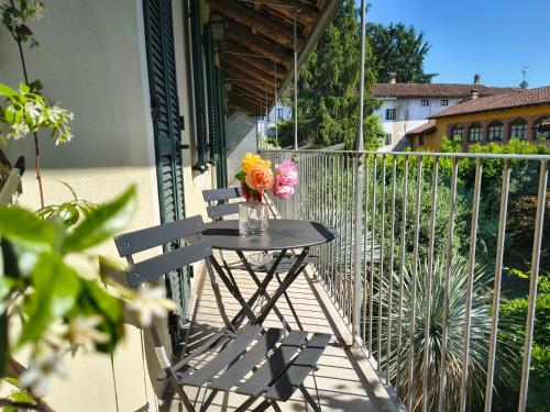 a table with a vase of flowers on a balcony at Alba Morus in La Morra