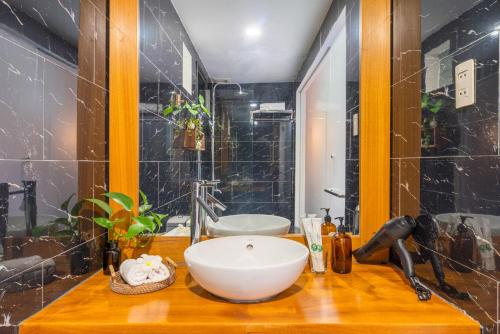 a bathroom with a white bowl sink on a wooden counter at The Coastal Haven pool villa in Hoi An