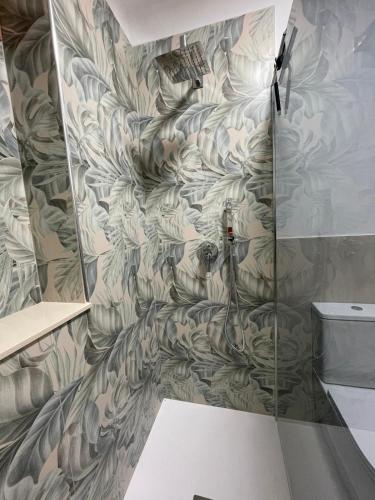 a shower stall in a bathroom with a wall at Villa Tommi a due passi dal mare in Fontane Bianche