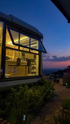 ein Glashaus mit Tisch und Stühlen bei Nacht in der Unterkunft Capsule Mountain in Lagunillas