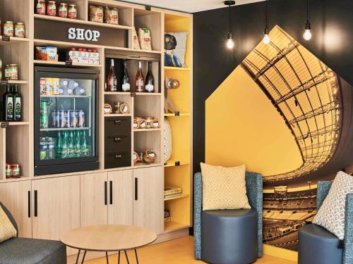 a shop with two chairs and a tv in a room at Aparthotel Adagio Access Paris Saint-Denis Pleyel in Saint-Denis