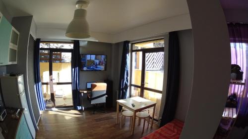 エストサドクにあるRider's DOM Euro Apart с Хаммамомのリビングルーム(窓2つ、テーブル、椅子付)