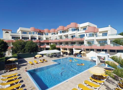 un hotel con piscina con sedie e ombrelloni di Grand Muthu Forte Da Oura ad Albufeira
