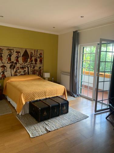 a bedroom with a bed with a suitcase on the floor at A Casa do Lagar in Azeitao