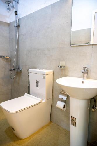 a bathroom with a toilet and a sink at Villa Whispering Leaves Kandy in Galaha Town