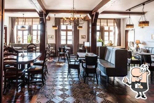 a restaurant with tables and chairs and a restaurant with a cartoon character at Altes Posthaus Ahlhorn in Großenkneten