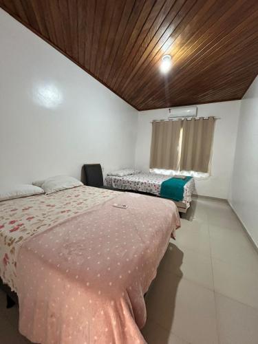 a bedroom with two beds and a wooden ceiling at Casa grande perfeita para grupos em Macapá in Macapá