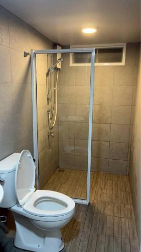 a bathroom with a toilet and a shower with a glass door at ชนแดนวิวเขา in Chon Daen