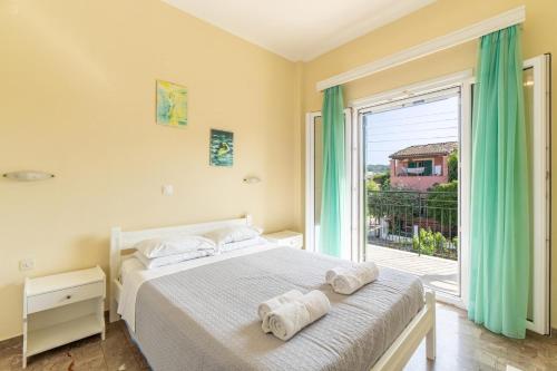 a bedroom with a bed and a large window at Katerina Pool Apartments in Acharavi