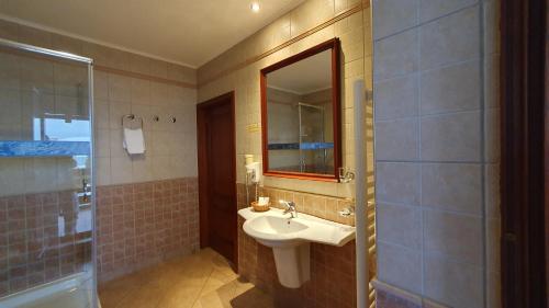 a bathroom with a sink and a mirror and a shower at GARDEN Club - Hotel & Restaurant - FREE Outdoor Pool & Parking in Braşov